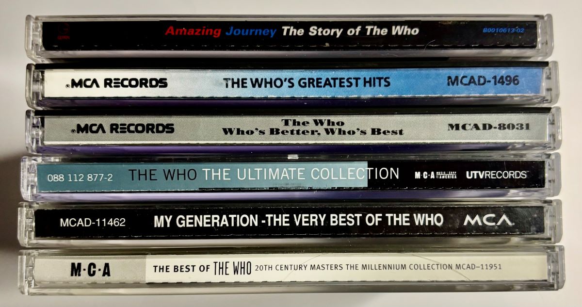 Six Who compilation CDs stacked with spine titles visible